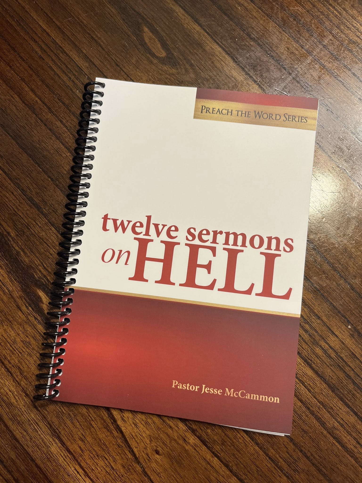Book titled 'Twelve Sermons on Hell' by Pastor Jesse McCammon on a wooden surface
